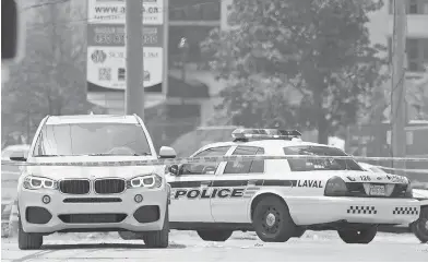  ?? GRAHAM HUGHES / THE CANADIAN PRESS ?? A white luxury SUV at the scene in Laval, Que., Friday, where alleged mobster Rocco Sollecito was gunned down.