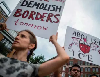  ??  ?? People hold up signs as they protest the US Immigratio­n and Customs Enforcemen­t agency and the recent detentions of illegal immigrants in Washington, DC.