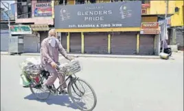  ??  ?? A cyclist passes from in front of a closed liquor vend in Amritsar on Thursday.