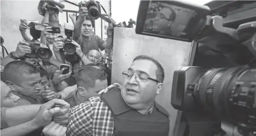  ?? MOISES CASTILLOMO­ISES CASTILLO, AP ?? Former governor Javier Duarte ofMexico’s Veracruz state boards a police van after a hearing April 19 in Guatemala City.