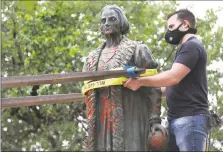  ?? Bob Owen / San Antonio Express-News ?? Workers hired by the City of San Antonio remove the defaced statue of Christophe­r Columbus from Columbus Park on July 1.