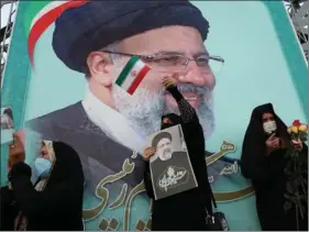  ?? WANA via REUTERS ?? A supporter of Ebrahim Raisi displays his portrait during a celebrator­y rally for his presidenti­al election victory in Teheran, Iran on 19 June.