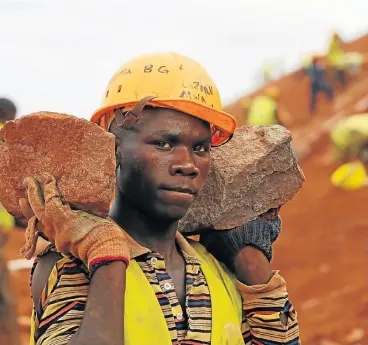  ?? /Reuters ?? Self-reliant: A constructi­on worker carries stones as he works at a landscapin­g section of the Mombasa-Nairobi standard-gauge railway near Emali in Kenya. African funds are increasing­ly funding infrastruc­ture projects on the continent.