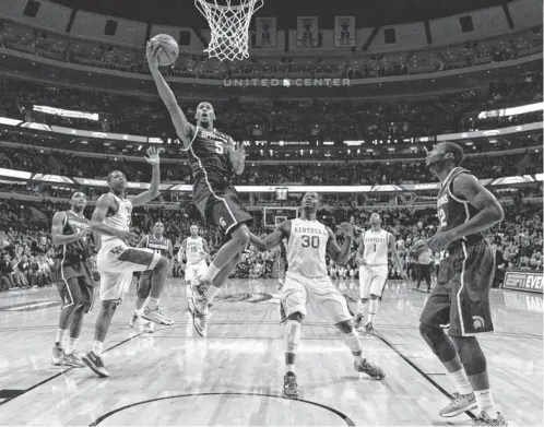  ?? DENNIS WIERZBICKI, USA TODAY SPORTS ?? Michigan State’s Adreian Payne goes up for a shot past Kentucky’s Aaron Harrison ( 2) and Julius Randle ( 30) in the first half Tuesday night at the United Center in Chicago. Payne had 15 points for the Spartans.