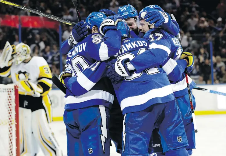  ?? — THE ASSOCIATED PRESS ?? Tampa Bay Lightning centre Steven Stamkos is swarmed by teammates after scoring a goal against the Pittsburgh Penguins on Thursday.