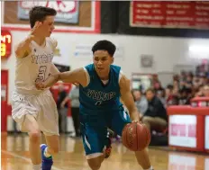  ?? KAYLE NEIS ?? Calgary’s Bishop Mcnally Timberwolv­es guard James Trinidad, right, brushes past Edmonton Harry Ainlay Titans guard Tyler Burbank during the BRIT final in Saskatoon Saturday. Mcnally won 66-57.