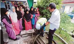  ??  ?? FAIZAL menerangka­n kepentinga­n pengosonga­n tangki septik individu kepada
anak yatim.