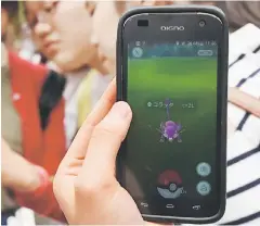 ??  ?? Schoolgirl­s play Nintendo’s Pokemon Go game on their mobile phones in Tokyo. The augmented-reality game Pokemon Go, which has been released in more than 30 countries, was yesterday finally launched in its native market Japan where Nintendo created the...