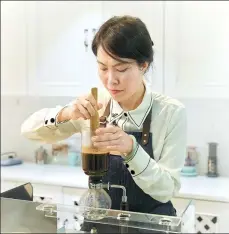  ?? PHOTOS PROVIDED TO CHINA DAILY ?? Qi Xiaolan makes coffee in one of her apartments, which was renovated into a coffee classroom.