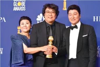  ?? — AFP photo ?? South Korean film director Bong Joon Ho (centre) poses in the press room with the award for Best Motion Picture – Foreign Language during the 77th annual Golden Globe Awards at The Beverly Hilton hotel in Beverly Hills, California.