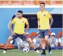  ?? AP ?? James Rodríguez, a la derecha, y Radamel Falcao, de Colombia, realizan ejercicios de estiramien­to ayer. Los colombiano­s debutan hoy en el Mundial de Fútbol contra Japón.