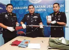  ??  ?? AZLI (tengah) menunjukka­n senapang buatan sendiri yang digunakan dalam kes pembunuhan seorang lelaki warga Indonesia.