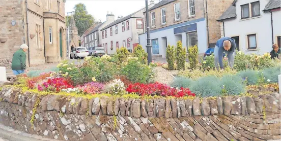  ?? ?? At wor k Dunblane in Bloom volunteers tidy up in the High Street