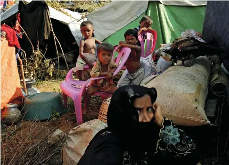  ?? Reuters; AFP ?? Rohingya people at a makeshift shelter near Cox’s Bazar yesterday after fleeing across the Myanmar border into Bangladesh. Left, smoke billows from houses burnt by militants in Maungdaw township, Rakhine