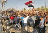  ??  ?? AFP Dozens of Iraqis shout slogans and wave national flags during a demonstrat­ion outside the local government headquarte­rs in the southern city of Basra on July 13, 2018.