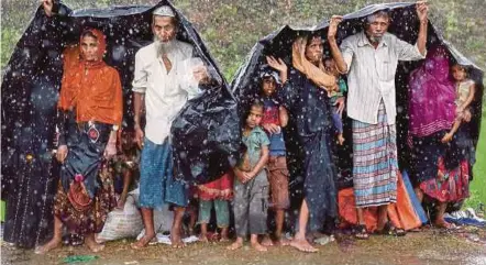  ?? PIC
REUTERS ?? Rohingya refugees sheltering from the rain in a camp in Cox’s Bazar, Bangladesh, yesterday.