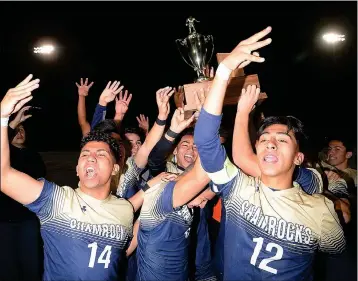  ?? PHOTO BY RANDY HOEFT/YUMA SUN ?? Yuma Catholic’s Daniel Castillo (14), Ramon Urbano (12) and their teammates hold up the state championsh­ip trophy and four fingers, signifying the Shamrocks’ fourth title in a row after defeating Chandler-Arizona College Prep 5-1 during Saturday’s Arizona Interschol­astic Associatio­n 3A Division Boys Soccer State Championsh­ip game at Williams Field High School in Gilbert.