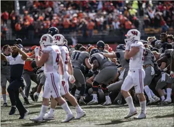  ?? HOLLY HART – THE ASSOCIATED PRESS ?? Wisconsin players walk off the field while Illinois celebrates its upset victory Saturday afternoon in Champaign, Ill.