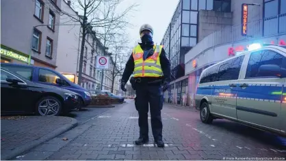  ??  ?? A Frankfurt police officer directs people away from a 700-meter exclusion zone for the unexploded World War II bomb