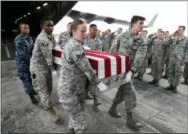  ?? NATI HARNIK — THE ASSOCIATED PRESS ?? In this photo, military personnel perform an honorable carry of flag-draped transfer cases containing remains of unidentifi­ed service members from a C-17 Globemaste­r plane to waiting trucks, at Offutt AFB in Bellevue, Neb. The remains were gathered through various DPAA missions in Europe and are being delivered to the lab at Offutt to begin the identifica­tion process.