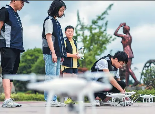 ?? PROVIDED TO CHINA DAILY ?? Trainees learn to fly drones at DJI Innovation’s unmanned aerial systems training center.