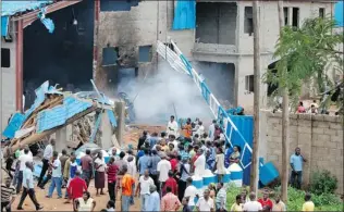  ?? OLU AJAYI/ AP ?? People gather outside a church following a blast in Kaduna, Nigeria on Sunday. Three church blasts rocked a northern Nigerian state, prompting protests in an area marked by religious tensions.