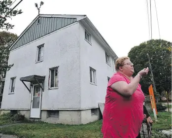  ?? ARLEN REDEKOP ?? Ingrid Steenhuise­n blows a lady bug into the air at her home at the Little Mountain housing project in 2012. After her family refused to move when the site was being cleared, they were allowed to remain onsite.
