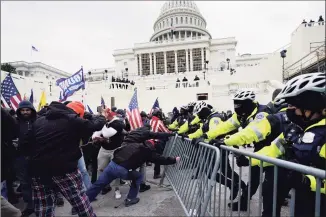  ?? Julio Cortez / Associated Press ?? Trump supporters try to break through a police barrier, on Wednesday at the Capitol in Washington.