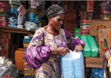  ?? ?? Kehinde, a retire principal, hold a pack of styrofoam in her store in Lagos.