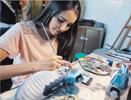  ?? ASSOCIATED PRESS FILE PHOTO ?? Paraguayan artist Lilian Cantero has received requests for her work from all over the world after Lionel Messi posed in a photograph with the boots that she sent him as a gift. She could hardly believe it when she saw the photo of a smiling Messi...