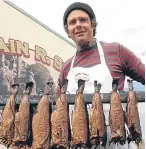  ??  ?? Robbie Boyd serves up smokies on the Iain R Spink stall.