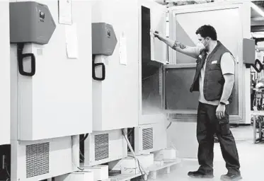  ?? MATTHIAS SCHRADER/AP ?? An employee at medical device manufactur­er Binder GmbH checks an ultra-low temperatur­e freezer Nov. 24 in Tuttlingen, Germany. These freezers could become a crucial part of Germany’s immunizati­on program when vaccines roll out.