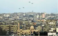  ?? MOHAMMED HAJJAR / AP ?? Humanitari­an aid is dropped by the United States on Saturday over Gaza City, Gaza Strip.