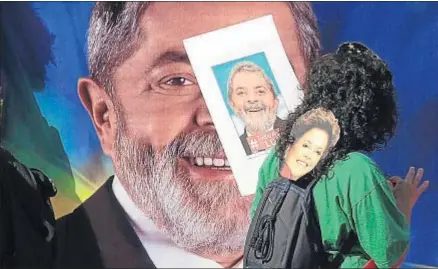  ?? SEBASTIÃO MOREIRA / EFE ?? Una mujer sostiene un cartel con una imagen de Lula da Silva y una careta de Dilma Rousseff