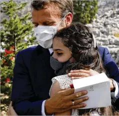  ?? GONZALO FUENTES / AP ?? French President Emmanuel Macron hugs blast victim Tamara Tayah after planting a cedar Tuesday near Beirut, as Lebanon struggles with economic crisis and government upheaval in the wake of the tragedy.