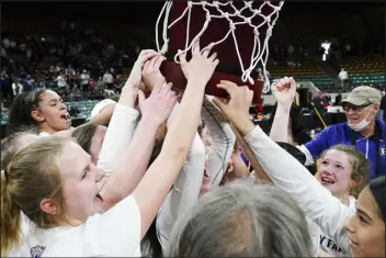  ?? REBECCA SLEZAK — SPECIAL TO THE DENVER POST ?? Holy Family players celebrate while holding the Class 4A state championsh­ip trophy on Saturday at Denver Coliseum. Holy Family defeated D’evelyn by the score of 49- 44.