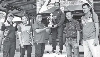  ??  ?? OVERALL CHAMPIONS: Yusrie (third left) presenting the trophy to Tawau team manager Mohd Rasyidy Mohd Sidek.