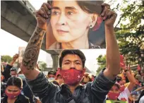  ?? ANDRE MALERBA/BLOOMBERG NEWS ?? A demonstrat­or holds up an image of Aung San Suu Kyi during a Feb. 1 protest outside the Embassy of Myanmar in Bangkok.