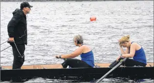  ?? JOE GIBBONS/THE TELEGRAM ?? Coxswain Jim Carroll looks on as crew members stroke Carolyn Coady (left) and No. 5 oar Michelle Davis regain their composure after finishing the first race of the morning – the Atlantic Lottery Female Amateur Race – at 8:00 a.m.