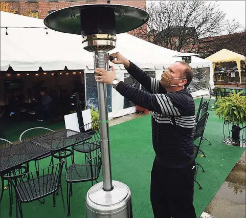  ?? Erik Trautmann / Hearst Connecticu­t Media ?? ONeill’s Pub co-owner Donny Leahy lights an outdoor heater in their parking lot on Friday in Norwalk. As winter approaches, the city and local restaurant­s are working together to make outdoor dining an option with tent and heater permits.