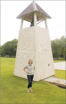  ?? LYNN KUTTER ENTERPRISE-LEADER ?? Vanessa McKuin with Historic Cane Hill, Inc., is in front of the bell tower at Cane Hill College. The bell was brought to the community in the 1850s after being recovered from the steamship Grapeshot, which sank in the Arkansas River. The ship captain was friends with faculty at Cane Hill College and offered the bell to the newly establishe­d school, according to “Cane Hill Images of America,” by Bobby Braly.