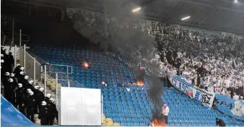  ?? Foto: Axel Heimken, dpa ?? Vermummte Gestalten fackelten mitten im Stadion Utensilien der Gegenseite ab. Die Polizei war zwar in großer Personalst­ärke anwesend, griff aber nicht ein, um eine weitere Eskalation zu vermeiden.