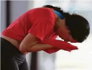  ??  ?? Top: Rafael Rios sweats as he leads his outdoor Zumba class at Langham Creek Family YMCA. Above: Ashley Hansen wipes away sweat with her T-shirt during the class.