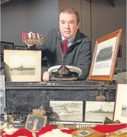  ?? Picture: Paul Reid. ?? Auctioneer and valuer, Geoffrey Taylor, with some of the set of items up for sale.