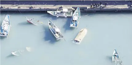  ?? REUTERS ?? An aerial view shows capsized boats believed to be affected by the tsunami caused by an underwater volcano eruption on the island of Tonga at the South Pacific, in Muroto, Kochi prefecture, Japan yesterday.