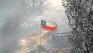 ?? // REUTERS ?? La bandera chilena ondea ante los restos de una casa en Viña del Mar