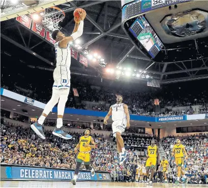  ?? KEVIN C. COX GETTY IMAGES ?? Canadian R.J. Barrett’s dunk got a rise out of Duke teammate Zion Williamson in the second half of Friday night’s NCAA Tournament win over the North Dakota State Bison. The Blue Devils led by just four points at the intermissi­on before taking over.