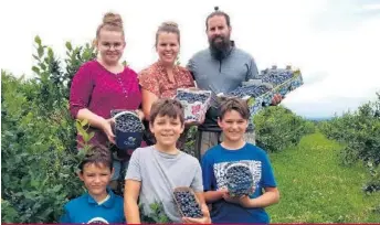  ??  ?? En compagnie de leurs quatre enfants (Marguerite, Léo, Olivier et Louis), Maggie Morissette et son conjoint Charles Beaudin, propriétai­res de la Ferme le versant fruitier, à Sainte-Claire dans Chaudière-Appalaches, profitent d’un gros achalandag­e de cueilleurs cette année.