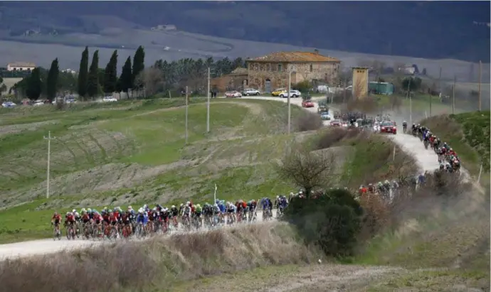  ?? © Luca Bettini/pn ?? Het peloton kronkelt over de Toscaanse onverharde wegen. Vorig jaar was Michal Kwiatkowsk­i de sterkste in de Strade Bianche.