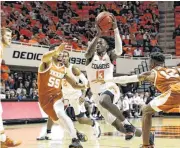  ?? [PHOTO BY EVAN BROWN FOR THE TULSA WORLD] ?? Freshman Oklahoma State guard Isaac Likekele protects the ball as he drives to the basket against the Texas Longhorns on Tuesday.